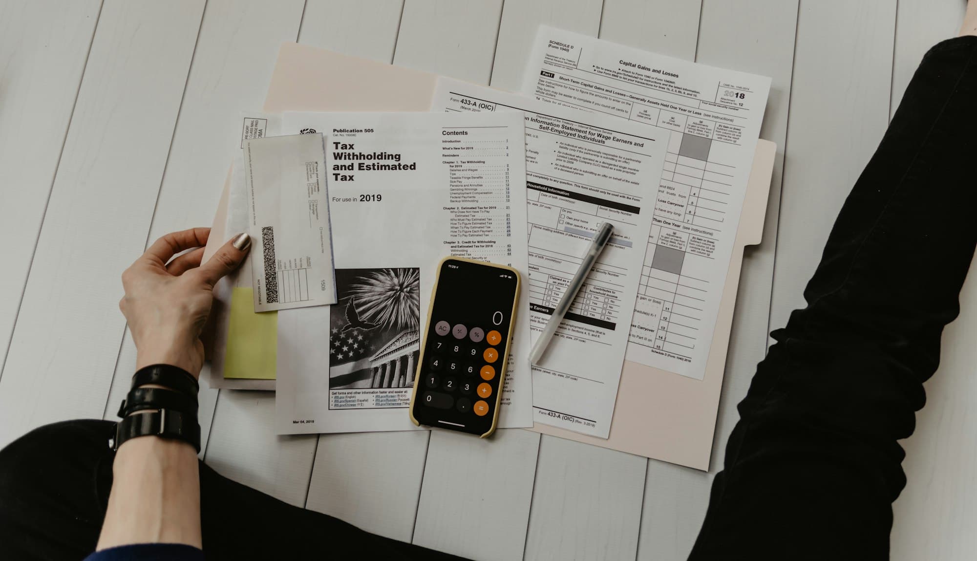 Hands reviewing financial statements with a calculator