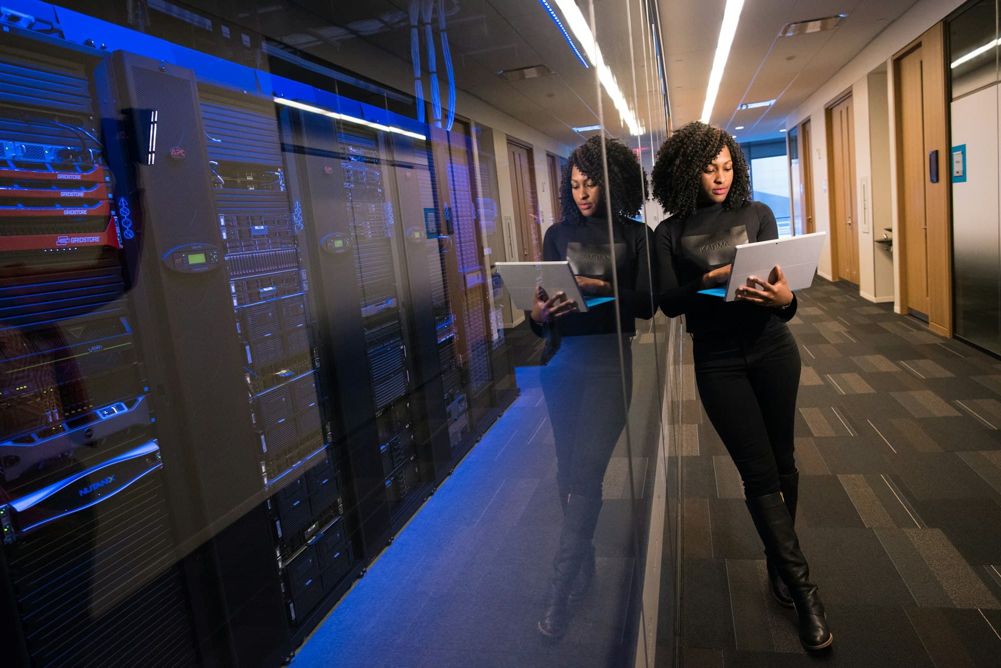 Engineer holding a laptop walking through a data center