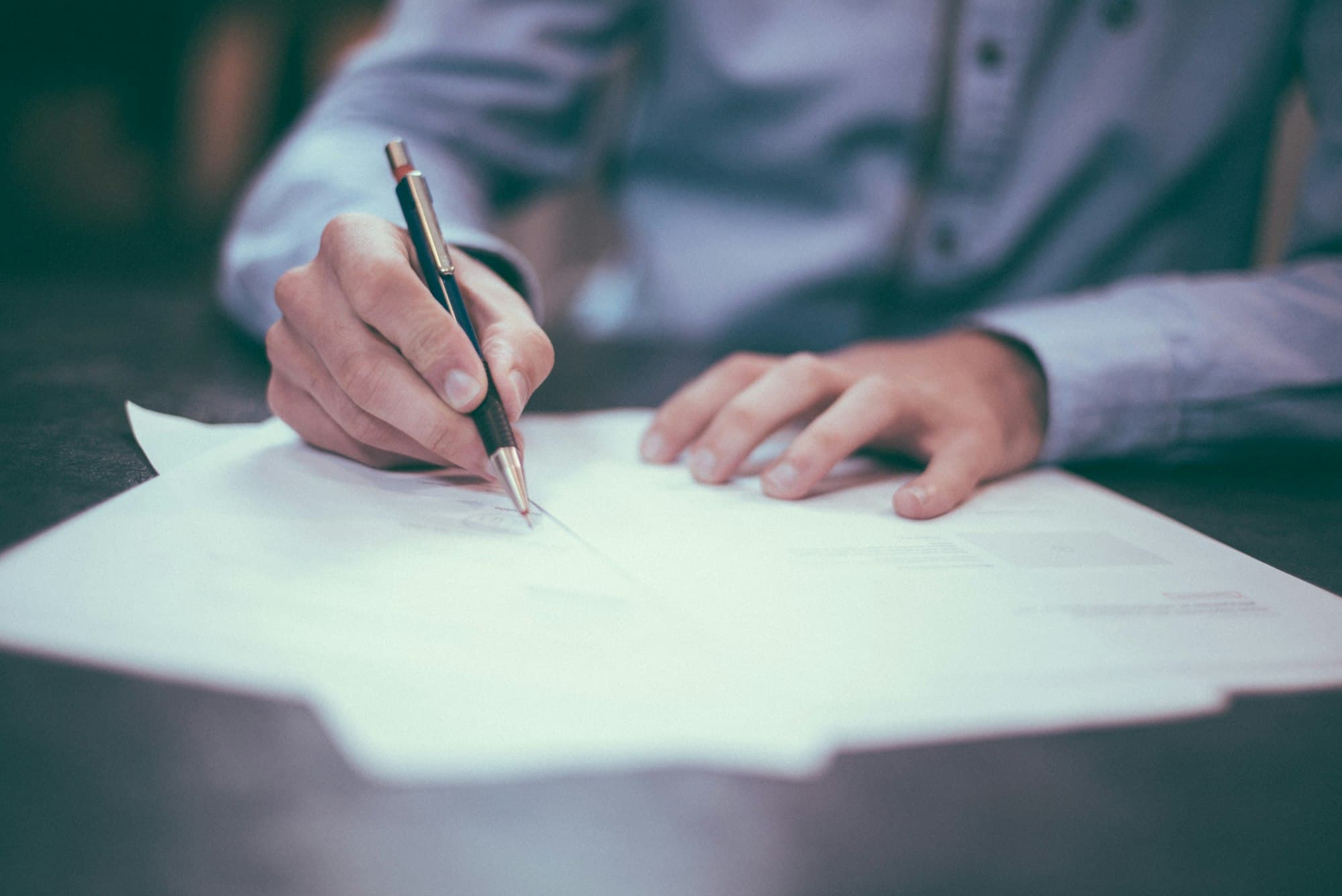 Hand signing paper documents with a pen